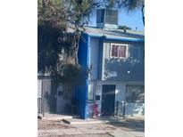 Modest two-story townhome featuring a painted blue accent wall, and a well-lit exterior, providing a cozy, inviting curb appeal at 809 E Cartier Ave # D, North Las Vegas, NV 89030