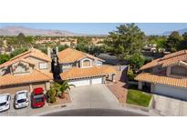 Two-story home with three-car garage, well-manicured lawn, and orange roof tiles at 8436 Kawala Dr, Las Vegas, NV 89128