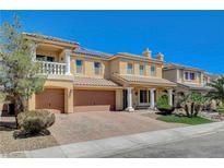 Stunning two-story home featuring an attached three-car garage and beautifully landscaped front yard with mature tree at 8448 Cambria Cellars Ct, Las Vegas, NV 89139