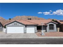 Charming single-story home featuring a three-car garage, desert landscaping and mountain views at 878 Samoy St, Las Vegas, NV 89110