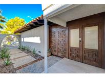Inviting entryway featuring a custom wood double door and landscaped walkway with desert plants at 945 Vegas Valley Dr, Las Vegas, NV 89109