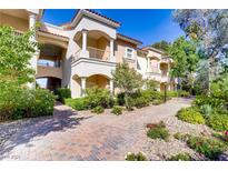 Beautiful building exterior featuring balconies, classic columns, and lush landscaping on a sunny day at 12 Strada Di Circolo, Henderson, NV 89011