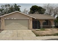 Single story house with a two car garage and gated front porch in need of some TLC at 2450 Oak Glen Way, Las Vegas, NV 89115