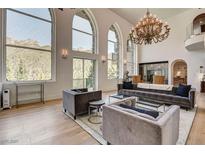 Bright living room featuring high ceilings, large windows, and a decorative chandelier at 4162 Matterhorn Way, Las Vegas, NV 89124