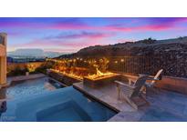 Inviting backyard with a pool, hot tub, fire feature, chairs, and city views at dusk at 778 Horizon Canyon Dr, Henderson, NV 89052