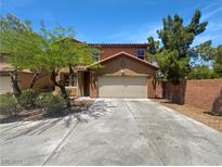 Charming two-story home with a desert landscape, spacious driveway, and a two-car garage, under a clear, bright sky at 8253 Pearl Oasis Ct, Las Vegas, NV 89139