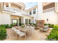 Luxurious outdoor patio with a dining table, comfortable seating, and a beautiful fireplace feature for elegant entertaining at 8895 S Tenaya Way, Las Vegas, NV 89113