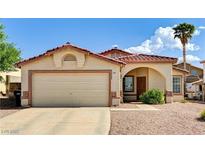 Inviting single-story home featuring a well-manicured yard, tiled roof, and attached two-car garage at 931 Highland Trails Ave, Henderson, NV 89015