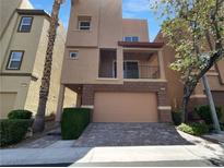 Modern two-story home featuring a brick facade, covered balcony, and a two-car garage at 9384 Hosner St, Las Vegas, NV 89178