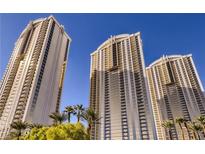 Striking exterior view showcasing the luxury high-rise condo buildings against a clear blue sky with lush greenery at 125 E Harmon Ave # 2718, Las Vegas, NV 89109