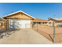 Single-story home featuring a driveway, garage and fenced yard at 1509 Lucilee St, Las Vegas, NV 89101