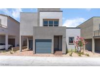 Modern two-story home with a gray exterior, attached garage, and small landscaped yard at 1799 Passerine St, Las Vegas, NV 89138