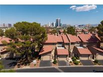 Townhomes with red tile roofs, attached garages and desert landscaping, set against the Las Vegas skyline at 3972 Tirana Way, Las Vegas, NV 89103
