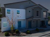 Two-story townhome featuring stucco facade and blue door for modern appeal at 4566 Mansart Ct # 1104, North Las Vegas, NV 89031