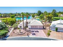 A charming one-story house features a three-car garage and lake in the background at 5401 Indian Hills Ave, Las Vegas, NV 89130