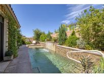 Inviting pool features a charming water feature and a serene seating area, enveloped by lush greenery at 606 Cadence Vista Dr, Henderson, NV 89011