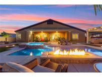 Stunning backyard pool with a spa, fire pit, and lounge chairs, perfect for outdoor entertaining at 6980 W Meranto Ave, Las Vegas, NV 89178