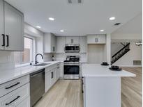 Bright kitchen features sleek countertops, stainless steel appliances, and island, plus modern cabinetry and fixtures at 71 Sea Holly Way, Henderson, NV 89074