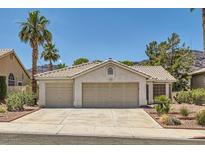 Charming single-story home with a two-car garage, desert landscaping, and mature palm trees in a desirable neighborhood at 735 Wolf Point St, Henderson, NV 89002