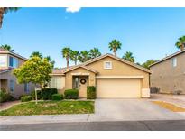 Charming single-story home featuring a well-manicured lawn, mature landscaping, and a two-car garage at 922 Lloyd George Dr, Henderson, NV 89052