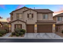 Two-story home features a two-car garage, tan stucco, and a red tile roof at 1073 Via Della Costrella, Las Vegas, NV 89101
