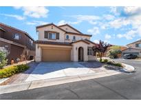 Two-story tan house with a two-car garage, arched entryway and a well-maintained front yard at 11238 Meadow Cove St, Las Vegas, NV 89179