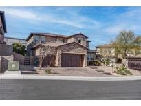 Beautiful two-story home featuring a stone facade and three-car garage, complemented by mature landscaping at 11952 Girasole Ave, Las Vegas, NV 89138