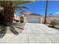Charming single-story home featuring a two-car garage and a well-manicured front yard with mature trees at 2324 Catskill Ct, North Las Vegas, NV 89031