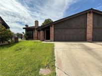 Charming single-story home with brick accents, a two-car garage, and a well-maintained lawn at 6521 Sugarpine Ln, Las Vegas, NV 89107