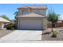 Beige two story home featuring a tile roof, two car garage and low maintenance landscaping at 730 Goshawk St, Henderson, NV 89015