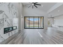 Bright living room boasts a fireplace, fan, and sliding doors to enhance the space at 11173 Concord Valley Dr, Las Vegas, NV 89135