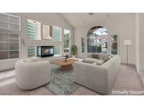 Bright living room with fireplace, vaulted ceilings, and large windows offering ample natural light at 1312 Fragrant Spruce Ave, Las Vegas, NV 89123