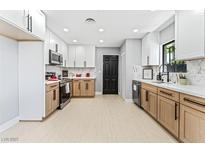 Bright kitchen featuring white and wood cabinets, stainless steel appliances, and light wood-look floors at 1415 Helen Ave, North Las Vegas, NV 89030