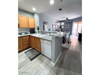 Well-lit kitchen featuring wood cabinets, stainless steel appliances, and an adjacent dining area at 23 E Agate Ave # 301, Las Vegas, NV 89123