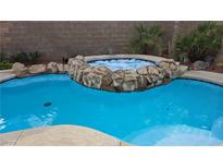 Sparkling pool and hot tub with rock accents, perfect for relaxation and outdoor enjoyment at 23 Indian Run Way, Las Vegas, NV 89148