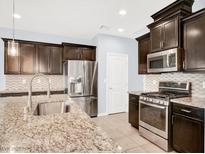Modern kitchen featuring granite countertops, stainless steel appliances, and ample cabinet space at 3712 Gilmore Creek St, Las Vegas, NV 89129
