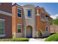 Attractive two-story home with a neutral color scheme, arched entryway, and desert landscaping at 9032 Retro Ct, Las Vegas, NV 89149