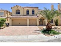Charming two-story home with a well-maintained lawn, mature palm tree, and a two-car garage at 10052 Baystone St, Las Vegas, NV 89141