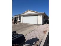Exterior view of home with a large driveway and two-car garage showcasing modern design at 105 Huntly Rd, Las Vegas, NV 89145