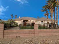 Beautiful desert home with palm trees and a brick wall-enclosed yard creates a welcoming curb appeal at 2851 Winchester Ave, Pahrump, NV 89048