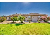 Charming single-story home with a well-manicured lawn and colorful flowering bushes at 2851 Winchester Ave, Pahrump, NV 89048