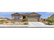 Tan single story home with stone accents, desert landscaping, and attached two car garage at 3964 E Marathon Dr, Pahrump, NV 89061