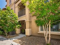 Charming front entry with cozy chair, balcony, and shade trees, inviting visitors into this lovely home at 4563 Townwall St, Las Vegas, NV 89115