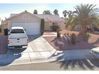 Charming single-story home with desert landscaping, mature palms, and a two-car garage at 4704 Wild Oak Way, North Las Vegas, NV 89031