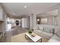 Bright living room features an open floor plan with a view of the kitchen and neutral color palette at 7836 Pinnochio Ave, Las Vegas, NV 89131