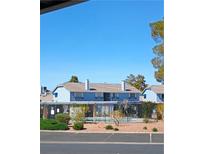 Inviting blue townhouse featuring a communal pool and secure black metal fence at , Las Vegas, NV 89122