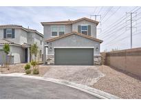 Two-story home with gray stucco, two-car garage and brick paver driveway in a suburban neighborhood at 10292 Fragrant Apple Ct, Las Vegas, NV 89141