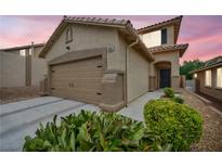 Inviting single-Gathering home featuring a two-car garage, desert landscaping, and a covered front entry at 10952 Napa Ridge Dr, Las Vegas, NV 89144