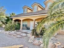 Inviting tan home with a well-maintained front yard and stone pathway at 425 Ross Ave, Overton, NV 89040