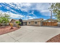 Charming single-story home with a large driveway, carport, and desert landscaping in front yard at 5203 Treasure Ave, Las Vegas, NV 89122